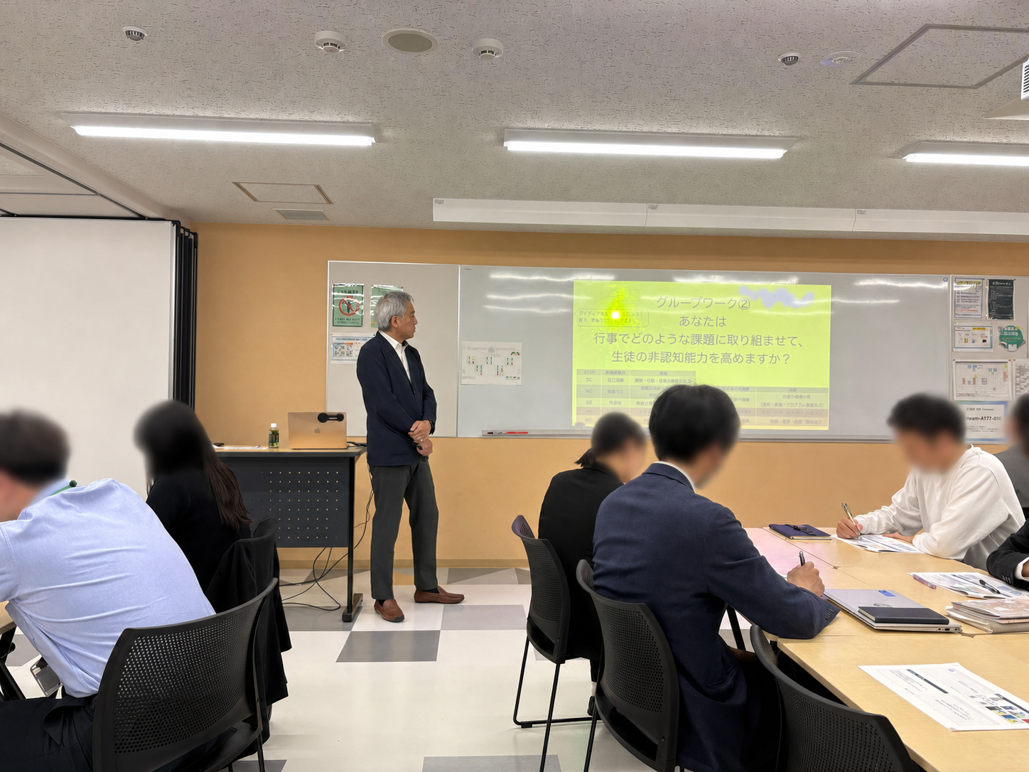 ワークシートに記入する学生と講師